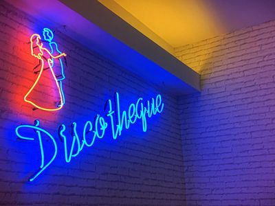 Silhouetted person stretching against a blue neon light.